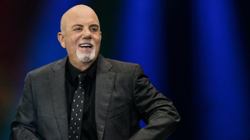 
		Billy Joel adia turnê após cair no palco e passar por cirurgia